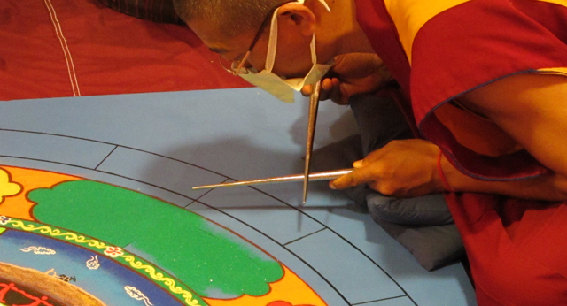 Tibetan Monk using chakpar to create Sand Mandala for Peace St. Louis